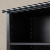 Close-up of the Zanzibar Bookcase's worn black finish and sturdy shelf support.