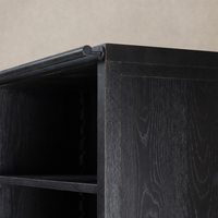Close-up of Zanzibar Bookcase featuring a worn black finish and sturdy construction.