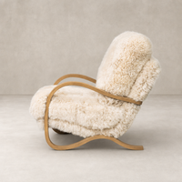Livia Chair in champagne Mongolian fur with curved wood arms and plush upholstery.