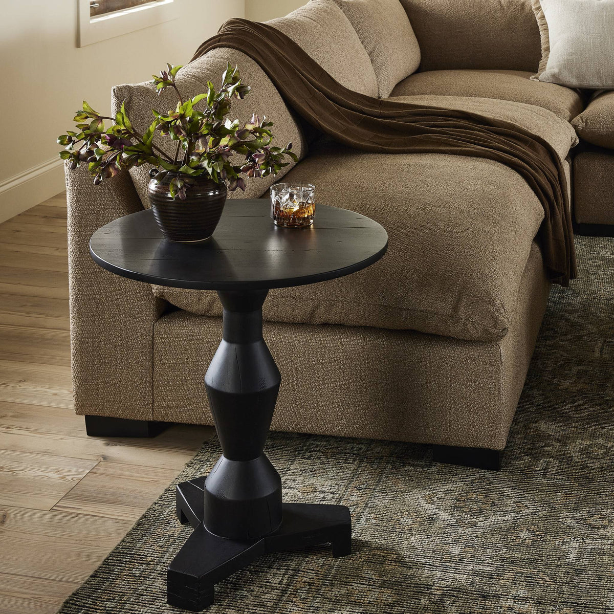 Neri End Table in black features a stylish round top and unique base design.