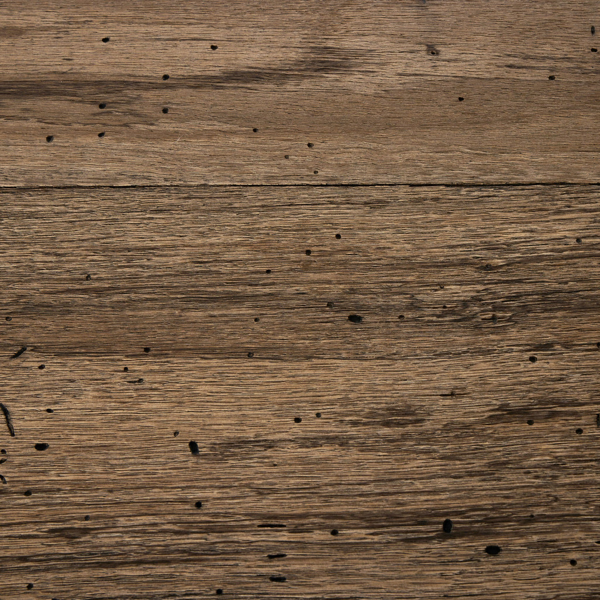 Close-up of Brisa Dining Table in rustic wormwood oak showcasing natural grain and texture.