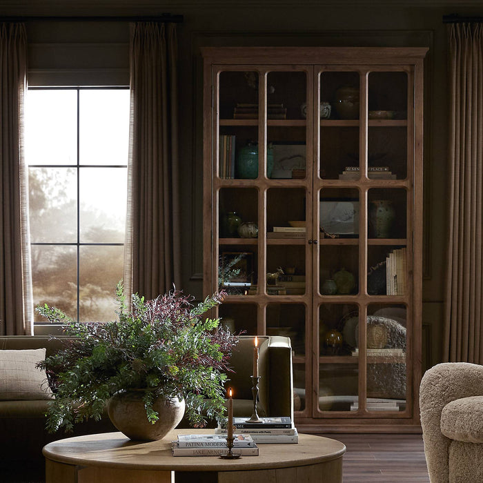 Lima Cabinet in weathered oak showcases glass-paneled doors and elegant shelving.