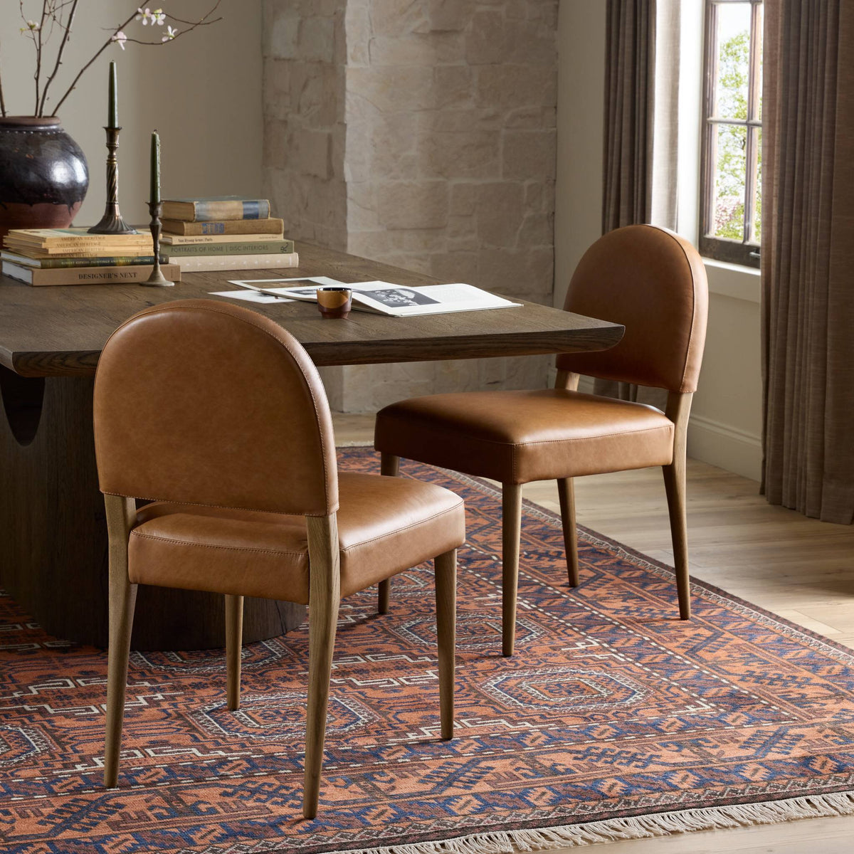 Marfa Dining Chair in Chaps Saddle, featuring a curved back and wooden legs in a dining setting.