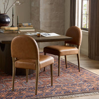 Marfa Dining Chair in Chaps Saddle, featuring a curved back and wooden legs in a dining setting.