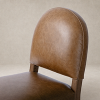 Marfa Dining Chair in Chaps Saddle features a rounded back and sleek design.