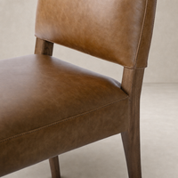 Marfa Dining Chair in Chaps Saddle with smooth leather upholstery and wooden legs.