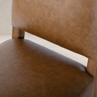 Marfa Dining Chair in Chaps Saddle with smooth leather and wooden legs.
