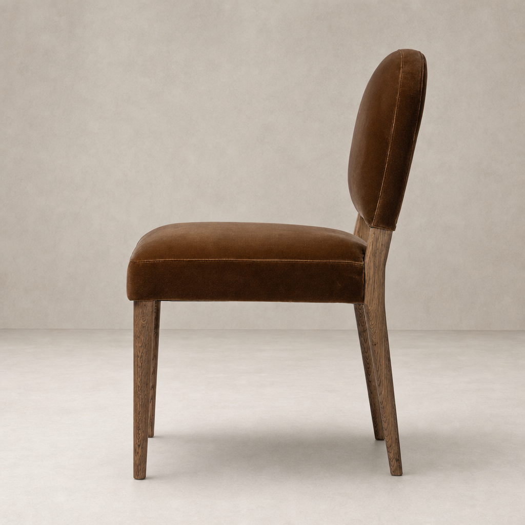 Side view of the Marfa Dining Chair in Surrey Ochre, featuring velvet upholstery and wooden legs.