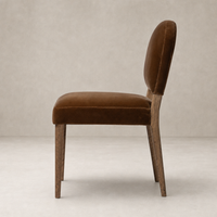 Side view of the Marfa Dining Chair in Surrey Ochre, featuring velvet upholstery and wooden legs.