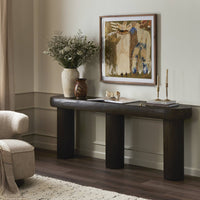 Close-up of the Maelle Console Table featuring a rounded design and rich dark finish, styled with decorative elements.