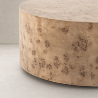 Calla Coffee Table in caramel burl features a smooth, rounded surface with unique textures.
