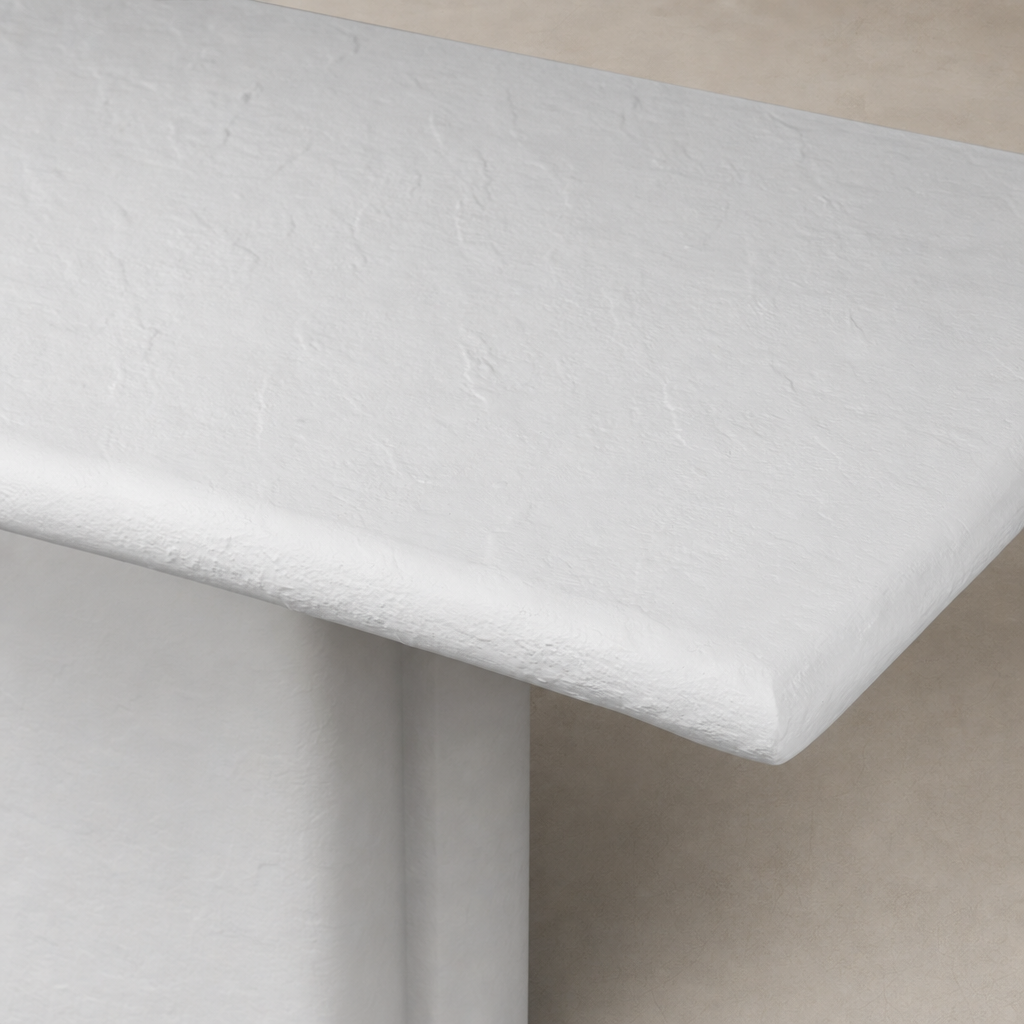 Close-up of Selby Dining Table in plaster molded concrete, showcasing its textured finish and rounded edges.