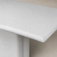 Close-up of Selby Dining Table in plaster molded concrete, showcasing its textured finish and rounded edges.