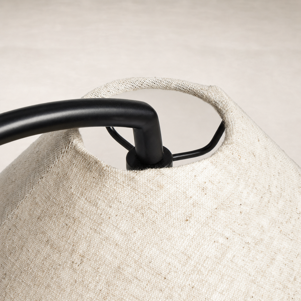 Matte black table lamp with a textured fabric shade and sleek curved design.