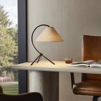 Matte black table lamp with a curved base and conical shade on a desk.