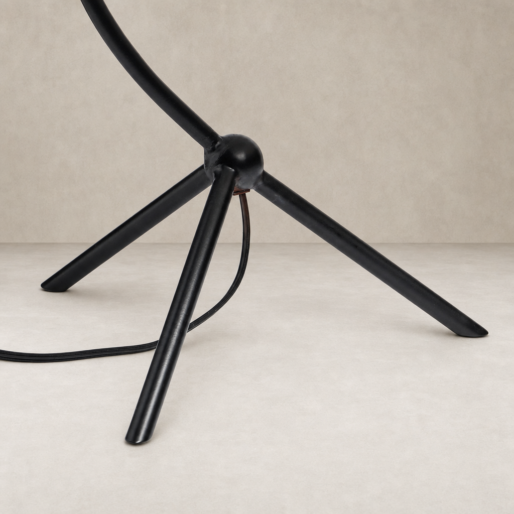 Matte black table lamp base featuring sleek tripod legs and rounded joint design.