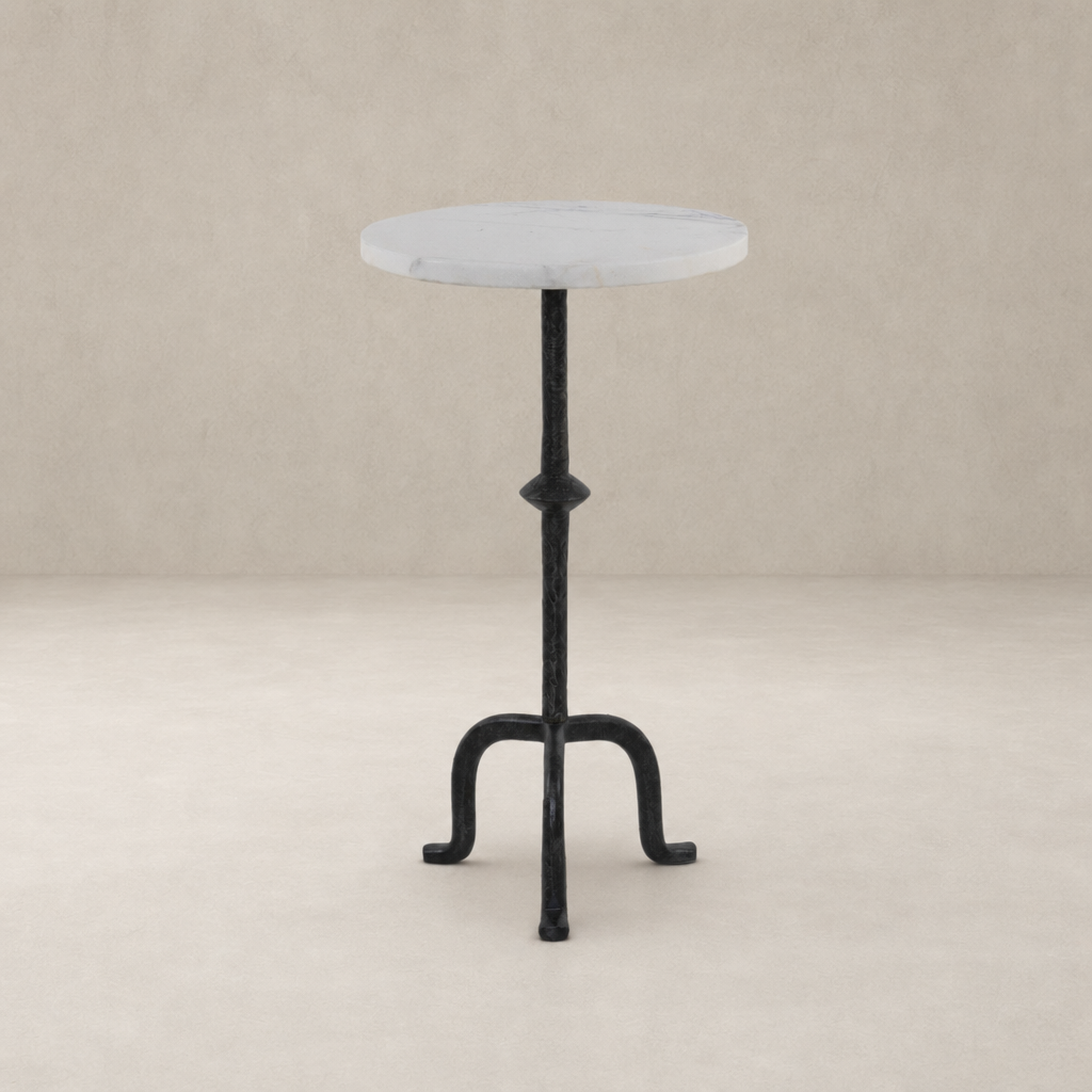 Esme End Table features a round marble top and intricate black metal base.