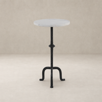 Esme End Table features a round marble top and intricate black metal base.