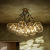 Burnished brass chandelier with clear glass globes and sleek black wires.