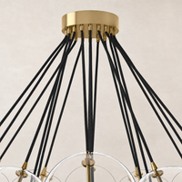 Burnished brass chandelier featuring unique black cord suspension and translucent globes.