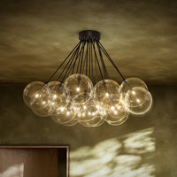 Black gunmetal chandelier with clear glass globes and exposed bulbs.