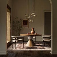 Black Gunmetal 7 Mix Chandelier hanging above a round wooden dining table.