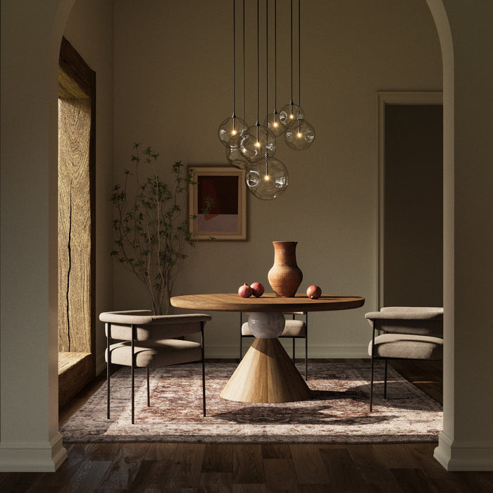 Black Gunmetal 7 Mix Chandelier hanging above a round wooden dining table.