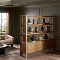 Zuma Wide Bookshelf in Worn Oak with decorative pottery displayed in a stylish living room.
