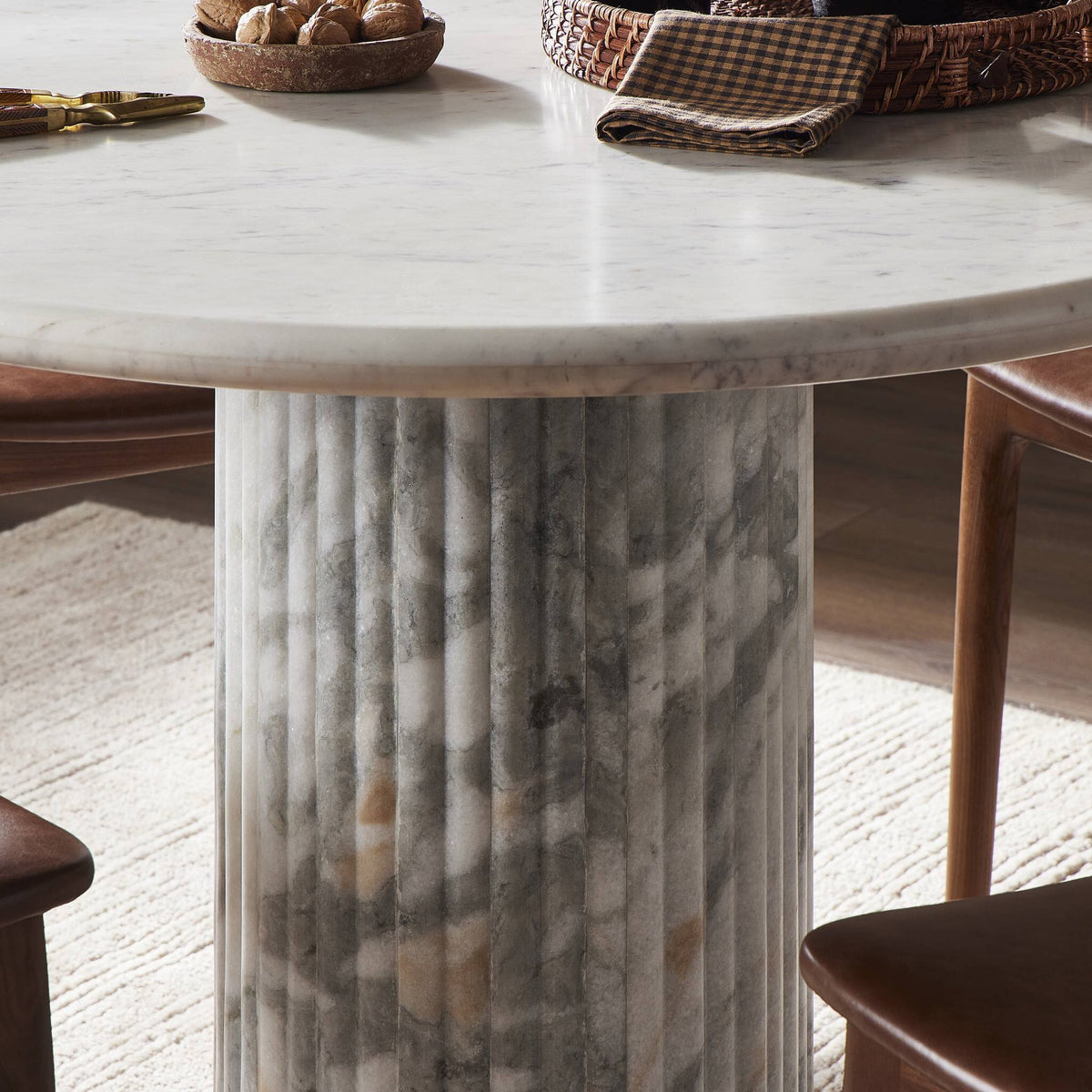 Ilaria Round Dining Table 42 features a polished white marble top and unique ribbed base.