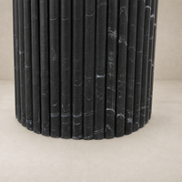 Close-up of the Ilaria Round Dining Table 42 featuring a textured black marble base.