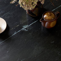 Ilaria Round Dining Table 42 with elegant black marble top and decorative accents.