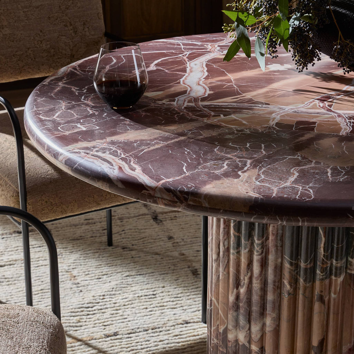 Ilaria Round Dining Table 42 in Merlot Marble features a smooth, elegant surface and fluted pedestal base.