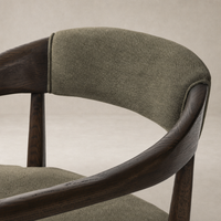 Close-up of the Nolan Dining Chair in Broadway Olive, showcasing its textured fabric and wood finish.
