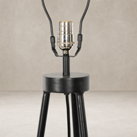 Matte black floor lamp base with a cylindrical shape and tripod legs.