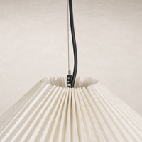Jet black pendant light with pleated cream shade and minimalist design.