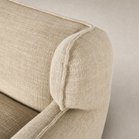 Close-up of Allora Swivel Chair in Saxon Sand, featuring textured fabric and rounded armrest.