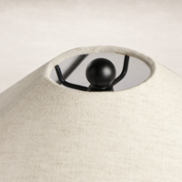 Matte black table lamp with a unique fabric shade and decorative finial.