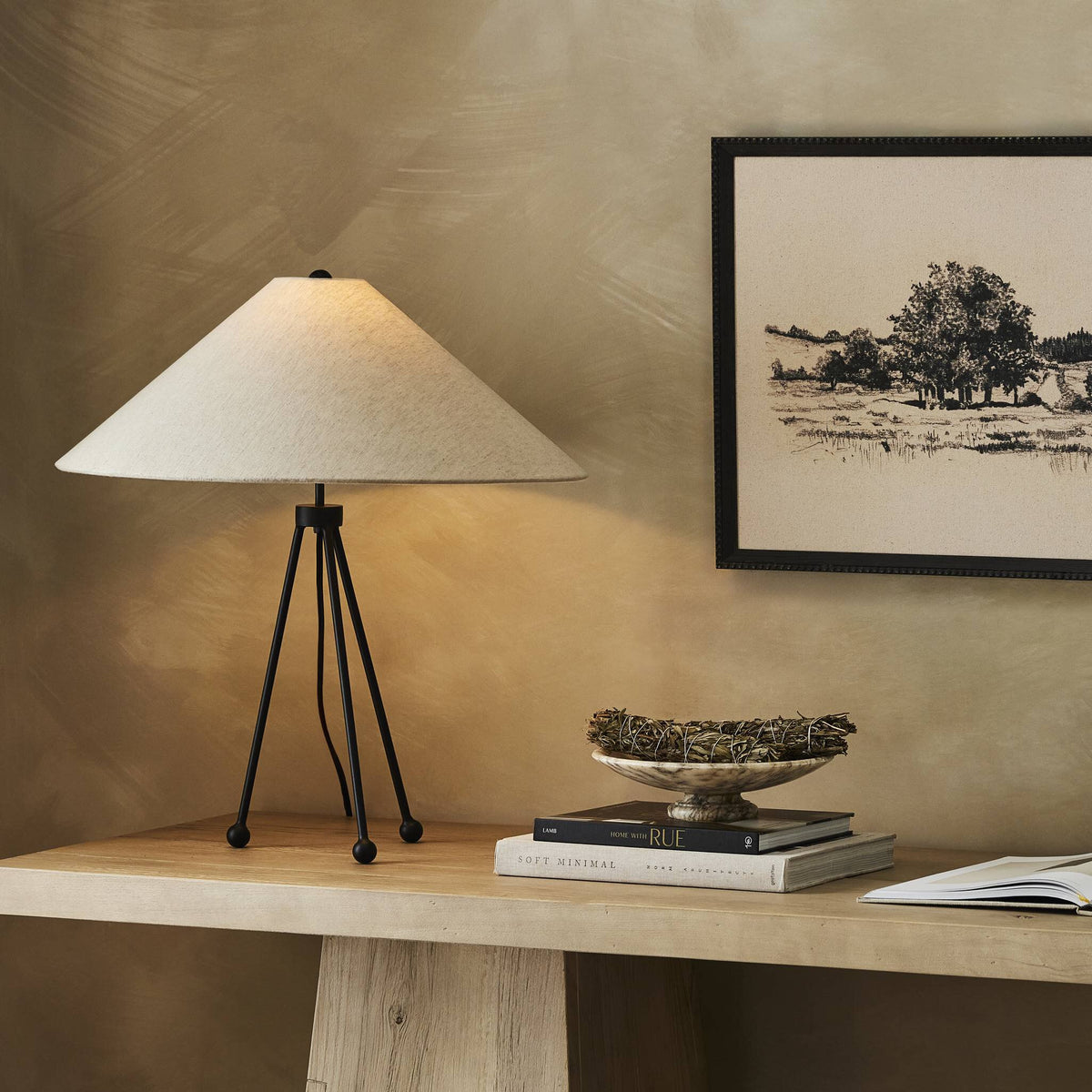 Matte black table lamp with a conical shade and tripod base.