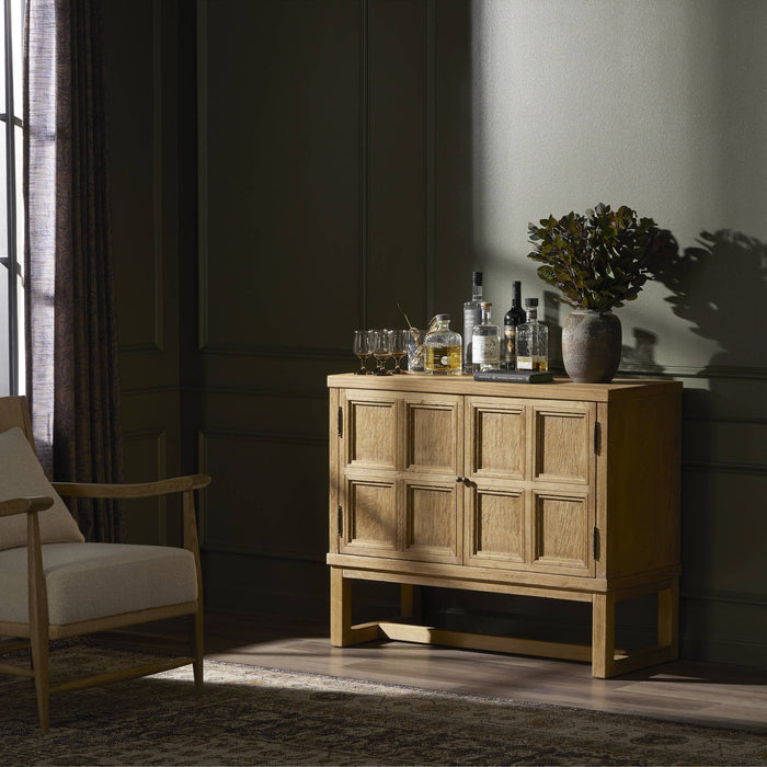 Worn Oak Samara Small Cabinet with paneled doors, styled with decor and drinks.