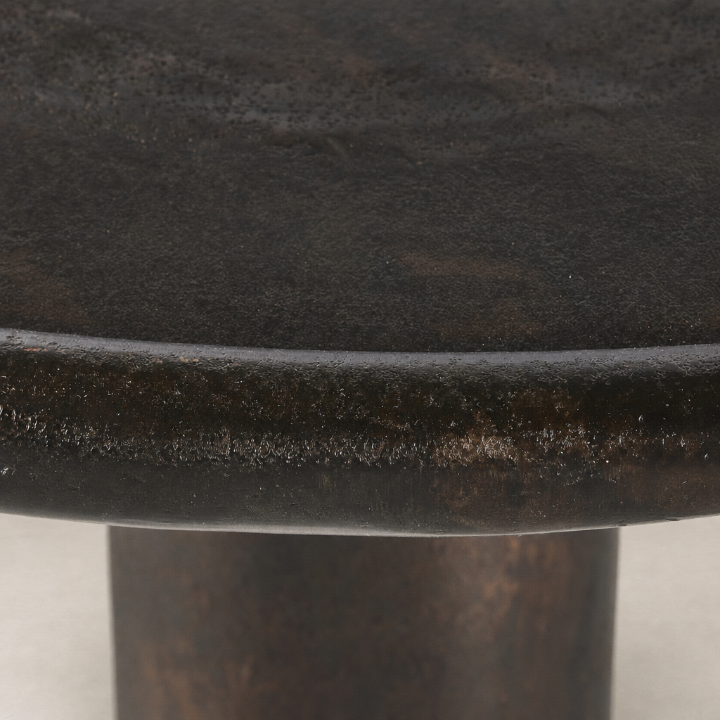 Close-up of the Cade Coffee Table in distressed bronze, highlighting its textured surface and rounded edge.