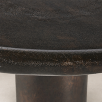 Close-up of the Cade Coffee Table in distressed bronze, highlighting its textured surface and rounded edge.