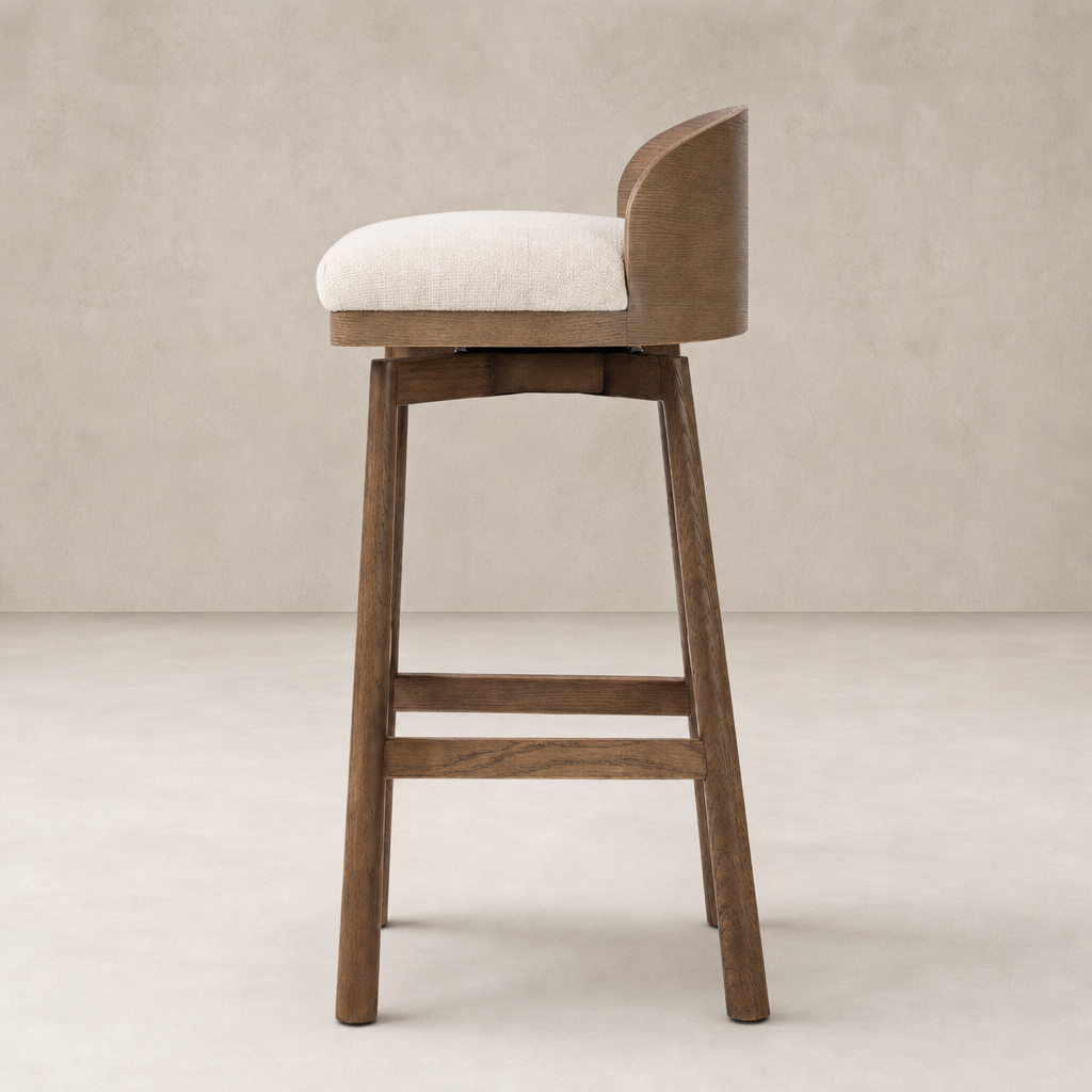 Quito Swivel Bar + Counter Stool in Thames Cream with a curved backrest and wooden legs.