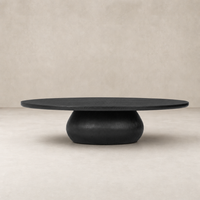 Ronan Coffee Table in worn black with a round top and sculptural base.