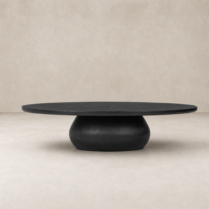 Ronan Coffee Table in worn black with a round top and sculptural base.
