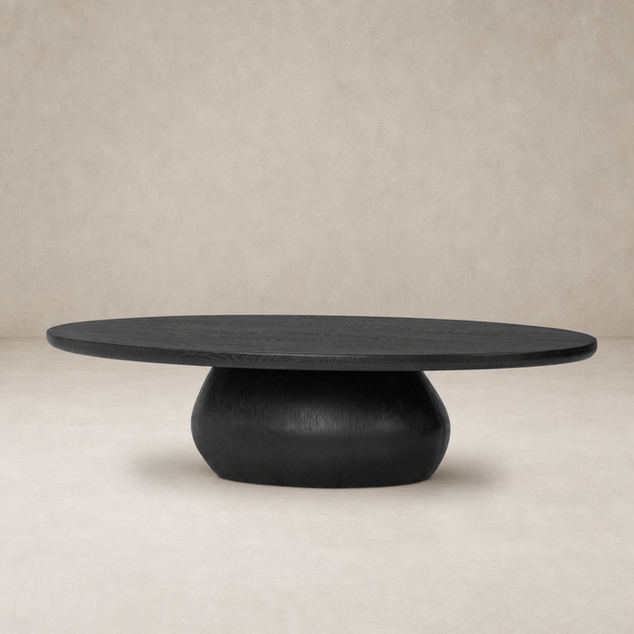 Ronan Coffee Table in worn black with an oval top and rounded base.