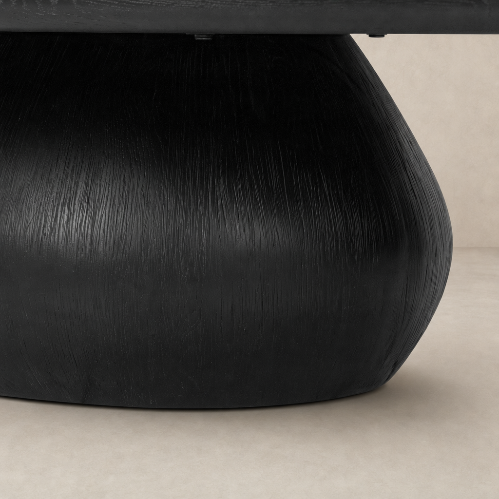 Worn black Ronan coffee table with a textured round base and smooth top.