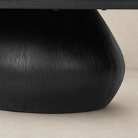 Worn black Ronan coffee table with a textured round base and smooth top.