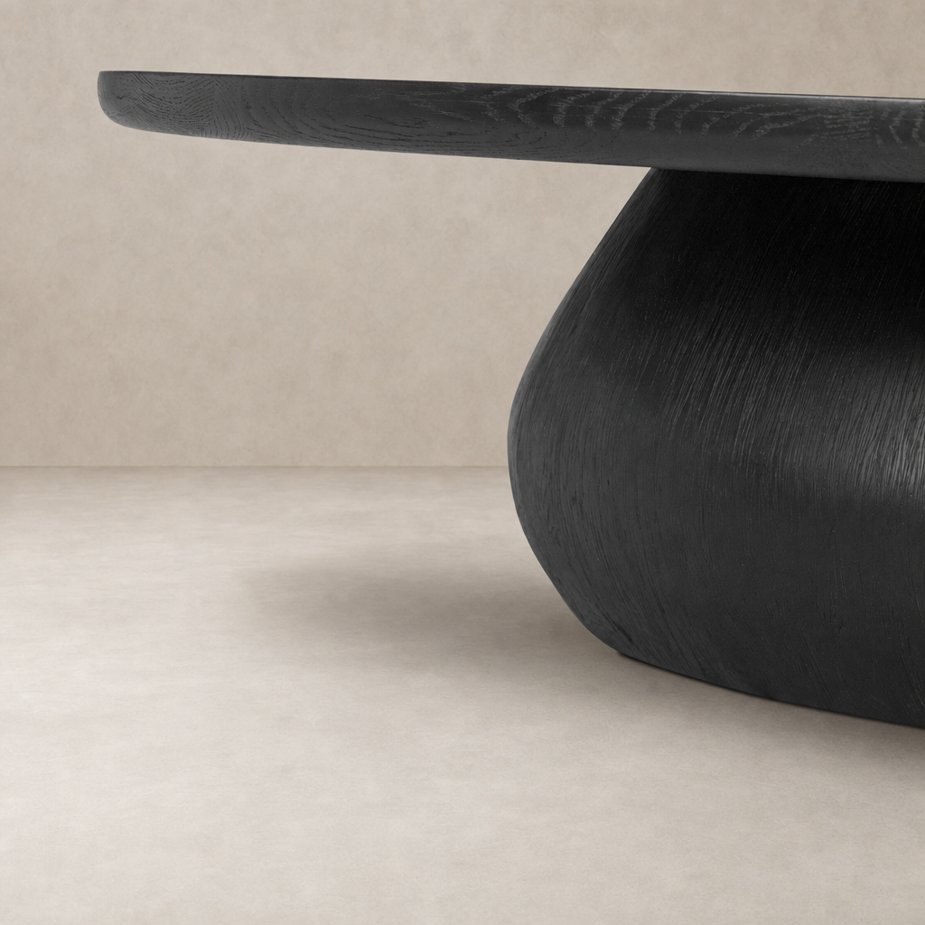 Ronan Coffee Table in worn black showcasing a smooth, rounded design and textured finish.