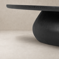 Ronan Coffee Table in worn black showcasing a smooth, rounded design and textured finish.