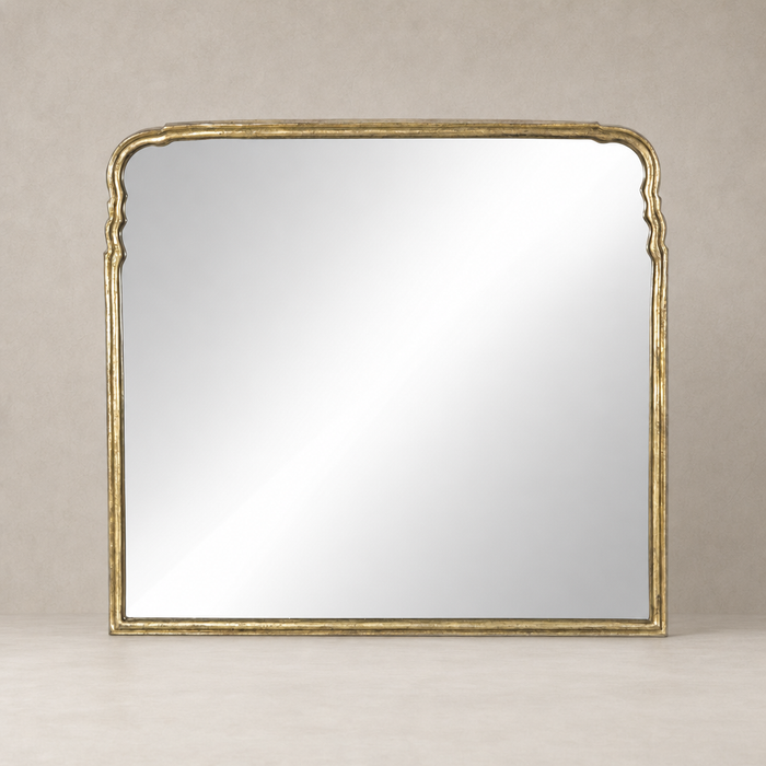 Seine Mantel Mirror featuring an elegant antiqued gold leaf frame with ornate curves.